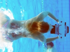 Potápěčka s pouzdrem a videokamerou uvnitř pod vodou